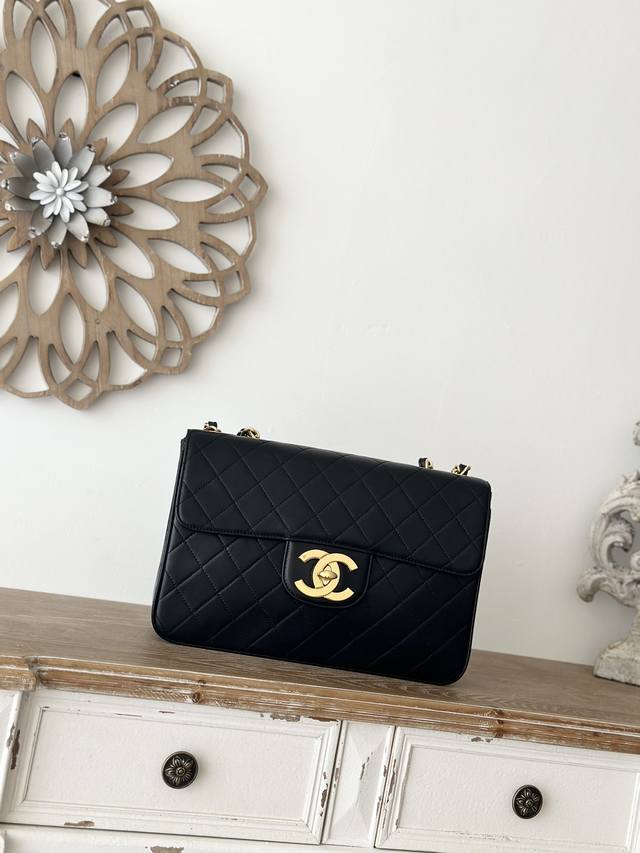 Victoria Beckham's Signature Chanel Black Lambskin Bag With A Large Gold Clasp.
