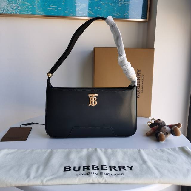 Burberry's exquisite shoulder bag is made of glossy leather and decorated with T