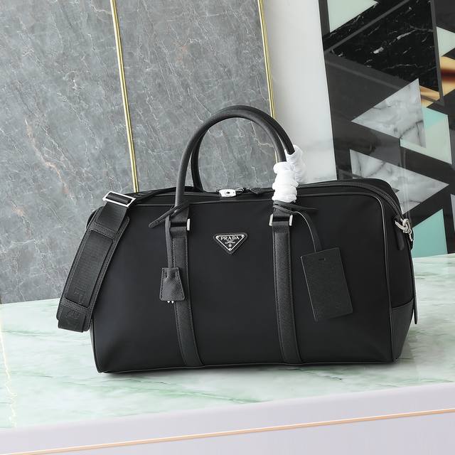 This Re-Nylon travel bag is trimmed with fine Saffiano leather for a modern and