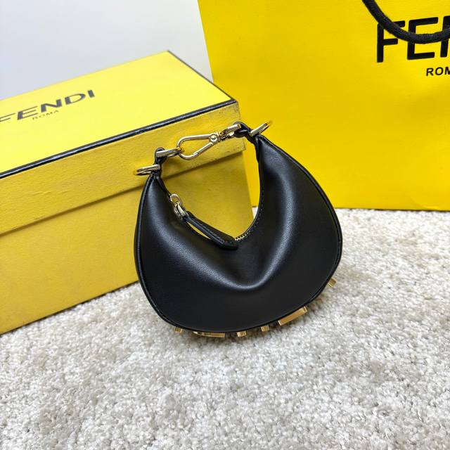 Small black Praphy underarm bag, featuring a crescent shape, with the classic me