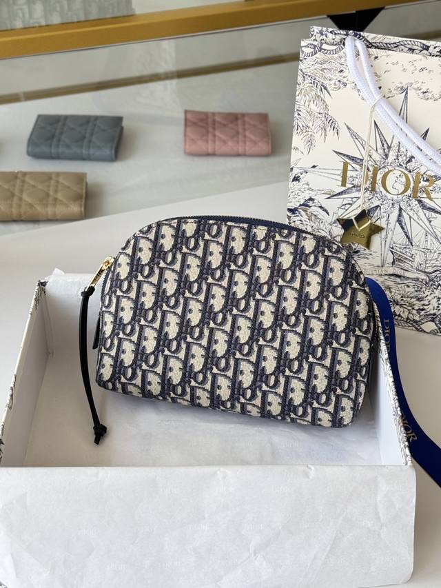 This bag features Dior's iconic blue Oblique print. It has two chic zippered co