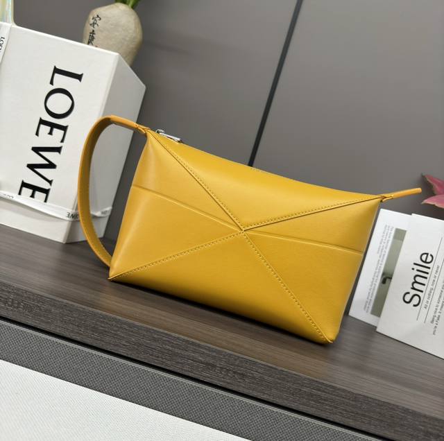 Low The new shiny cowhide wash bag is inspired by the geometric lines of the Puz