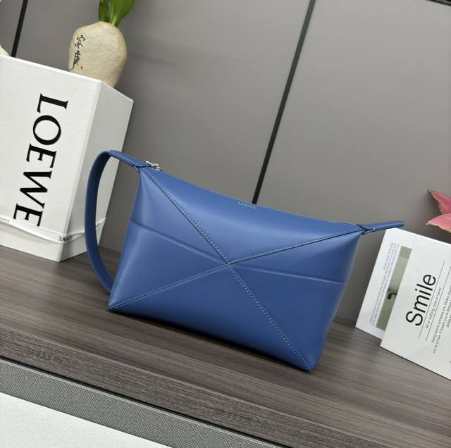 Low The new shiny cowhide wash bag is inspired by the geometric lines of the Puz