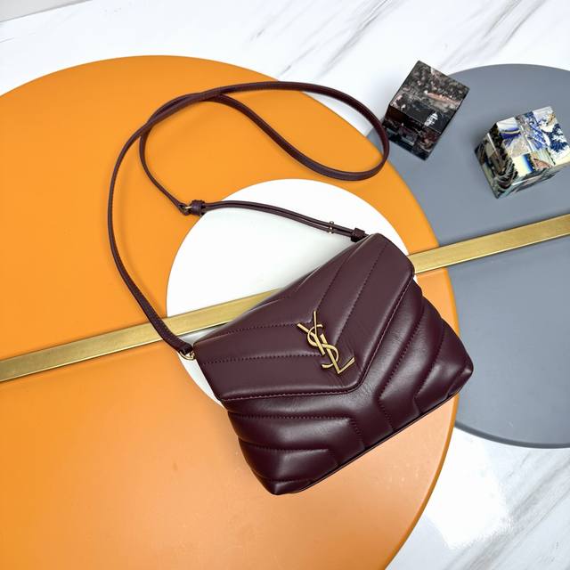 The original version of the P Loulou mini crossbody bag with red and gold buckle