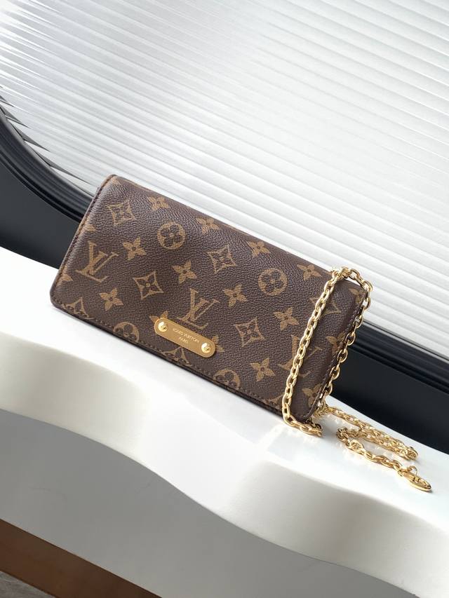 flap embellished with studs and a Louis Vuitton plaque. It offers ample storage