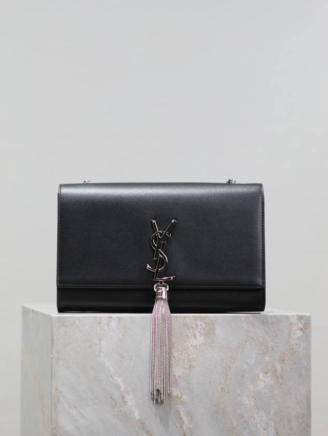 The timeless classic black, silver-buckled, plain-weave Kate 24cm tassel bag is