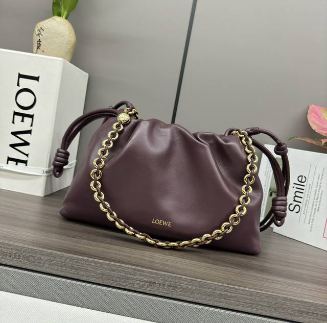The Flamenco Purse bag in low soft nappa leather features a pleated design and k