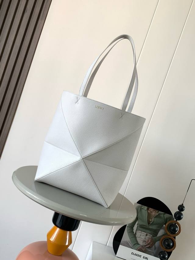 The new peony-faced cowhide Puzzle Fold handbag plays with geometric patterns ag
