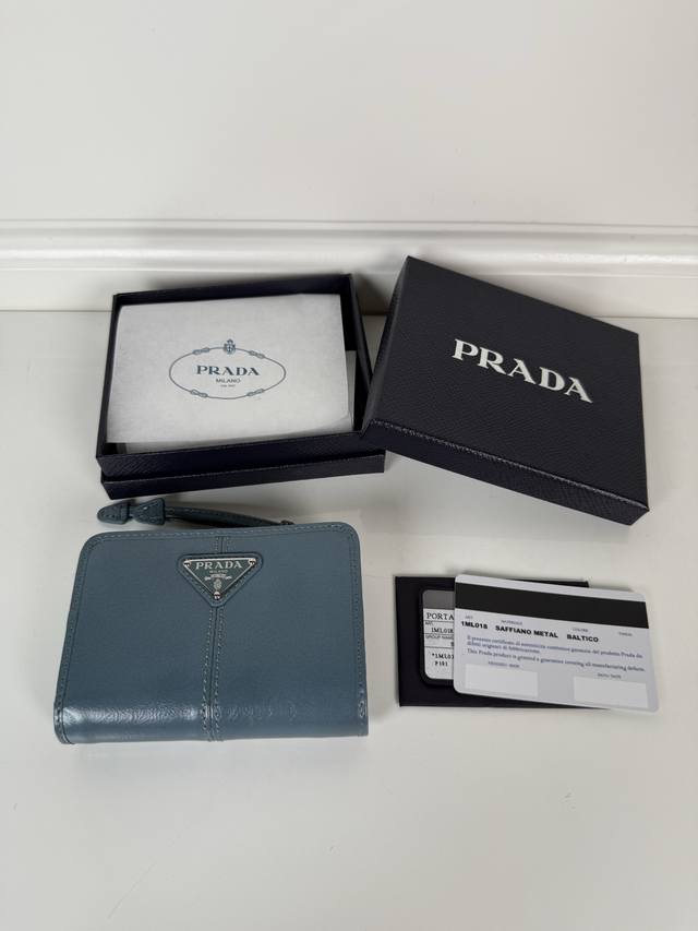 P is a short wallet made of blue oiled waxed cowhide, model number 1Ml018. It ha