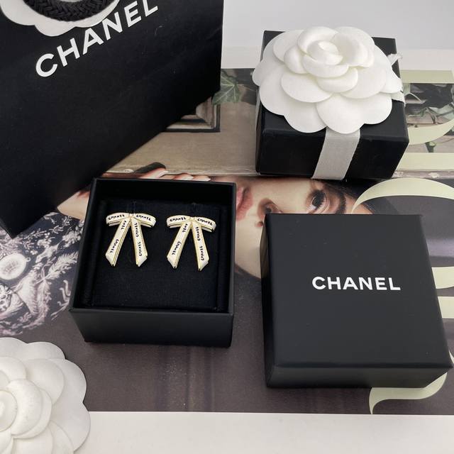We are featuring vintage Chanel earrings with black letters and white ribbon bow