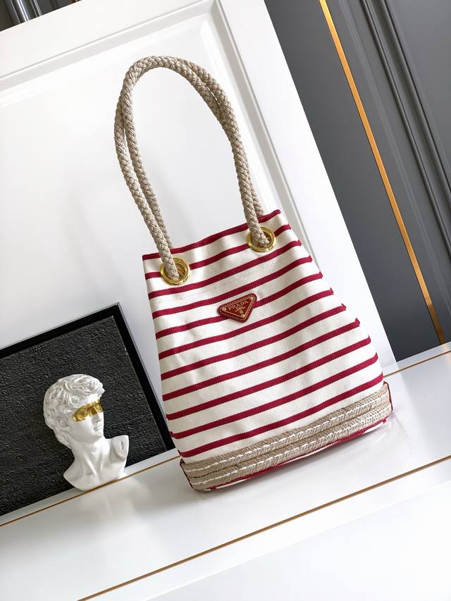 This fabric bucket bag features a nautical striped pattern, adding a touch of co