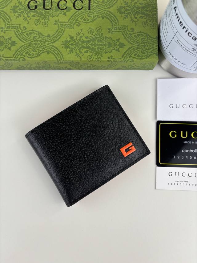Guccl's latest Gg Marmont short wallet features an orange G logo, black pigskin