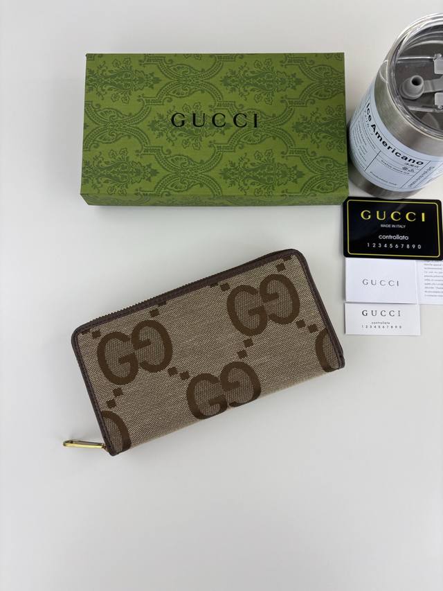 The Guccl zip-around wallet incorporates the brand's recognizable elements, fea