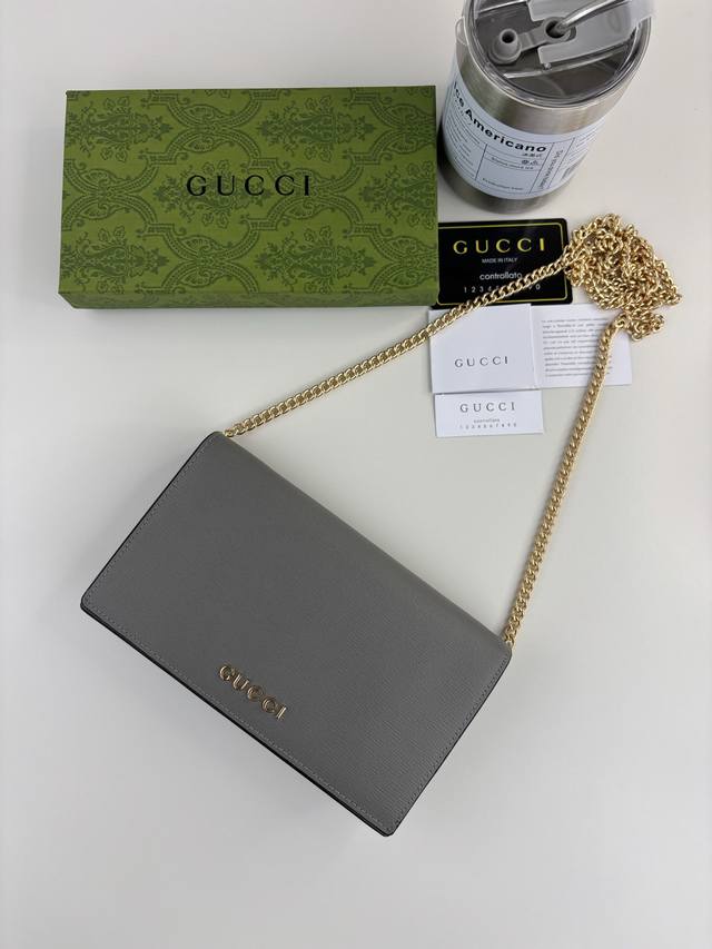 Guccl chain wallet with handwritten Gucci logo. The small leather accessories co