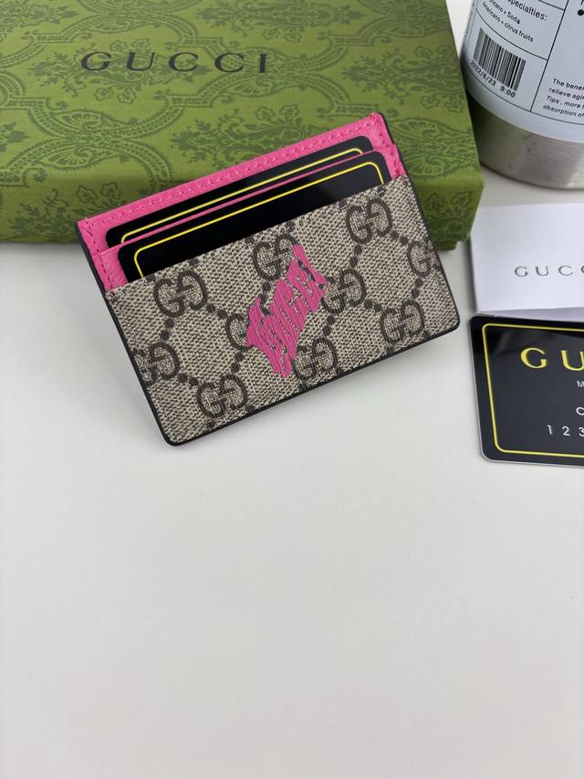Guccl This two-tone card holder is crafted from coated fabric with the iconic Gg