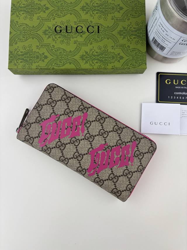 Guccl This zip-around wallet is crafted from coated fabric with the iconic Gg mo