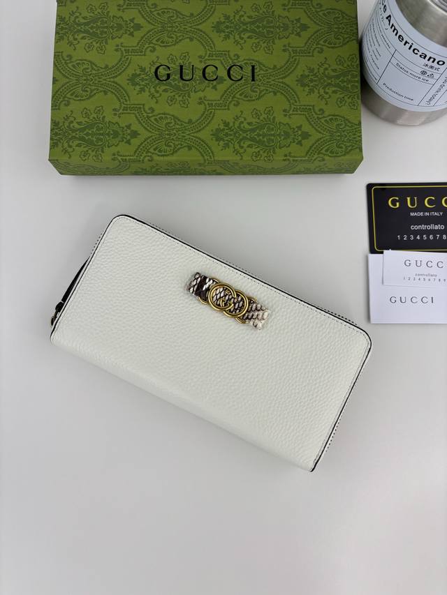 Guccl's latest wallet features an Interlocking G python bow. Crafted from genui