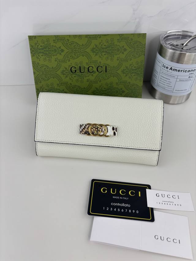 Guccl's latest wallet features an interlocking G python bow. Crafted from genui