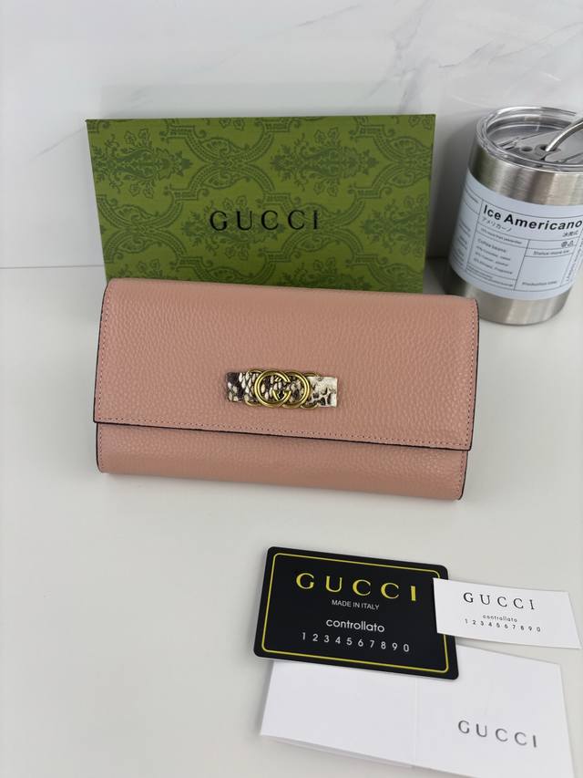 Guccl's latest wallet features an interlocking G python bow. Crafted from genui