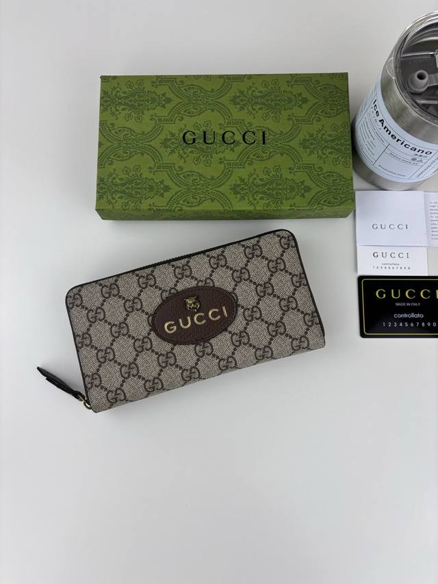 Guccl Apricot Gg Supreme PVC zipper wallet with oval leather label and tiger hea