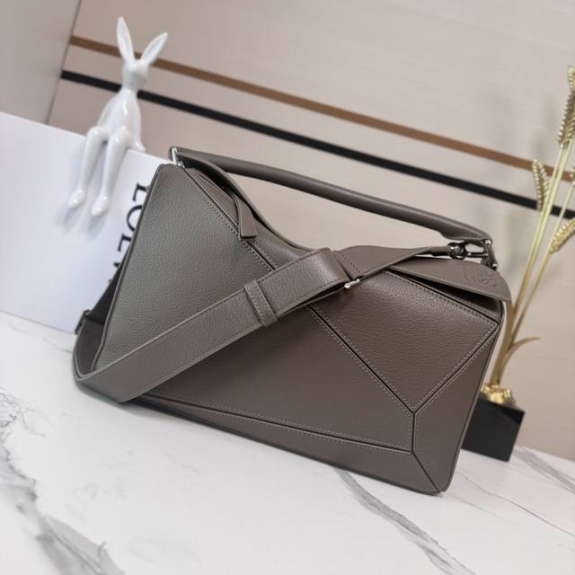 Low This large, soft deerskin puzzle bag features a rectangular shape defined by