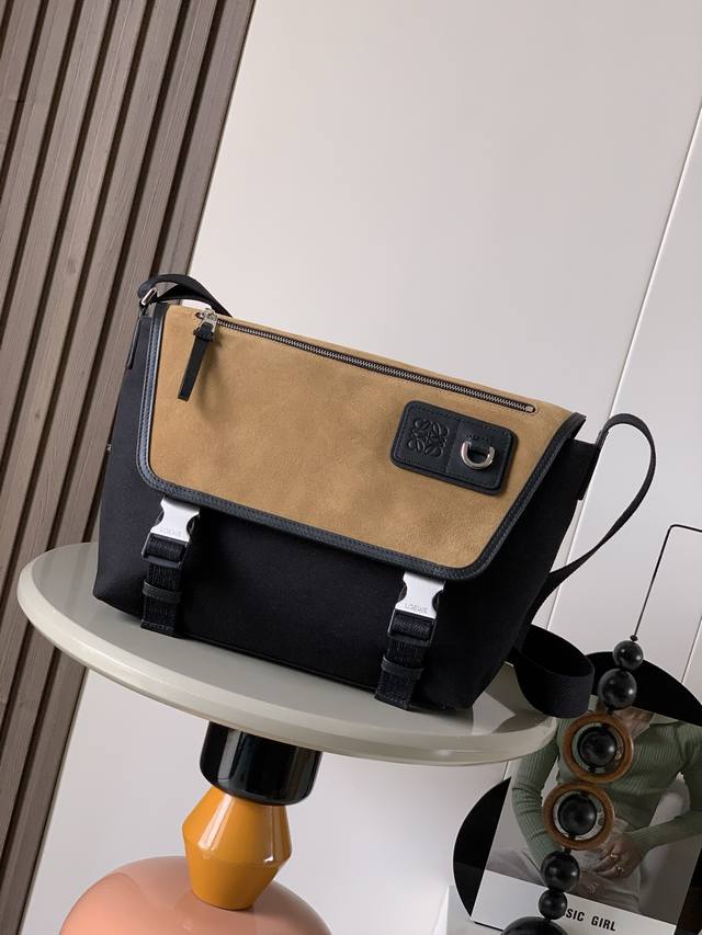 Medium Canvas and Suede Flex Messenger Bag. The Flex messenger bag features a tr