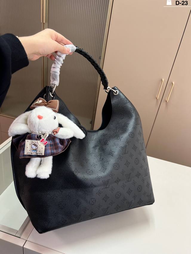 Comes with keychain. This Louis Vuitton Carmel bag, made with Mahina perforation