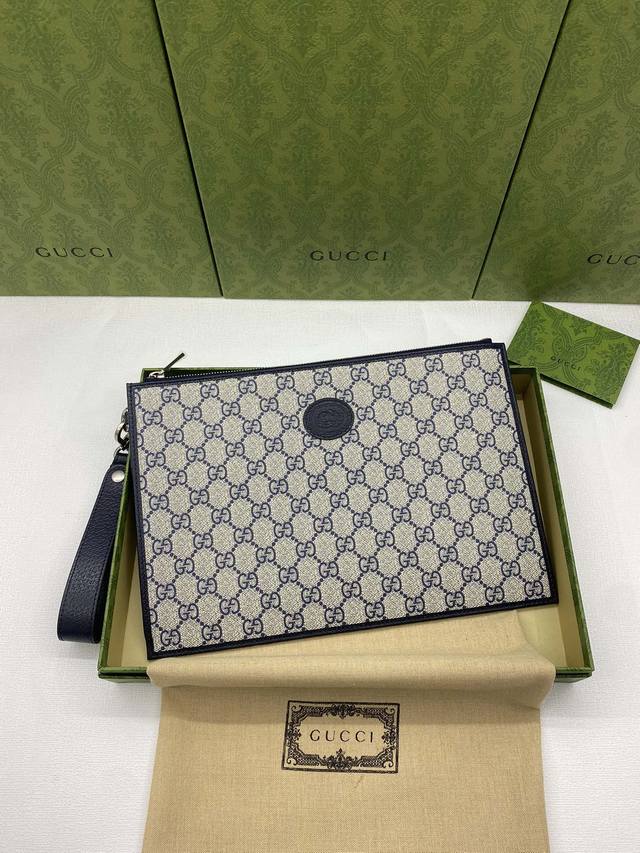 This new clutch bag comes in a green box and is made of blue Gg Supreme canvas