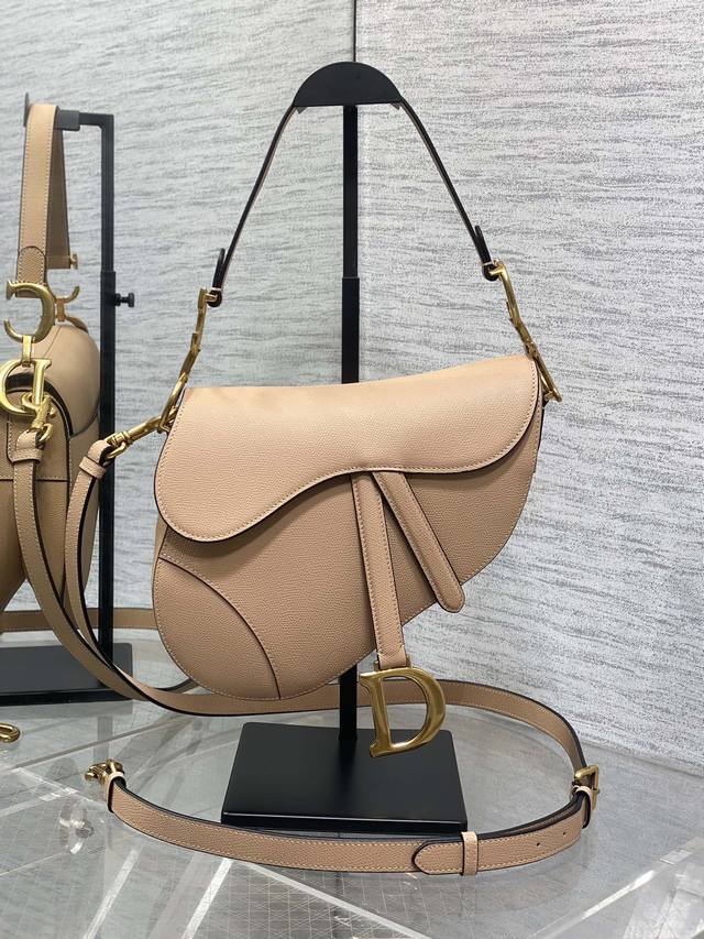 The classic saddle bag with a deep apricot color and long shoulder strap is the