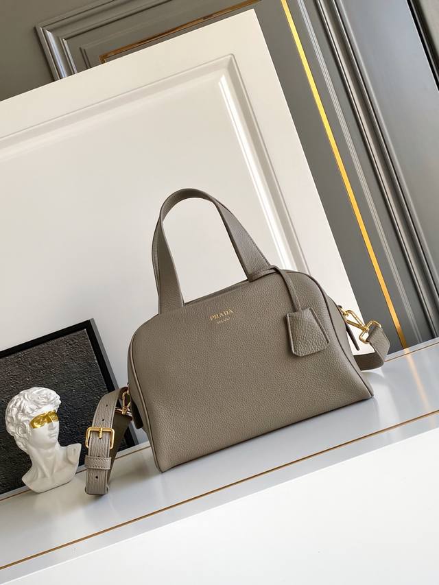 New This top-handle bag, crafted from natural grain leather, is reinterpreted wi