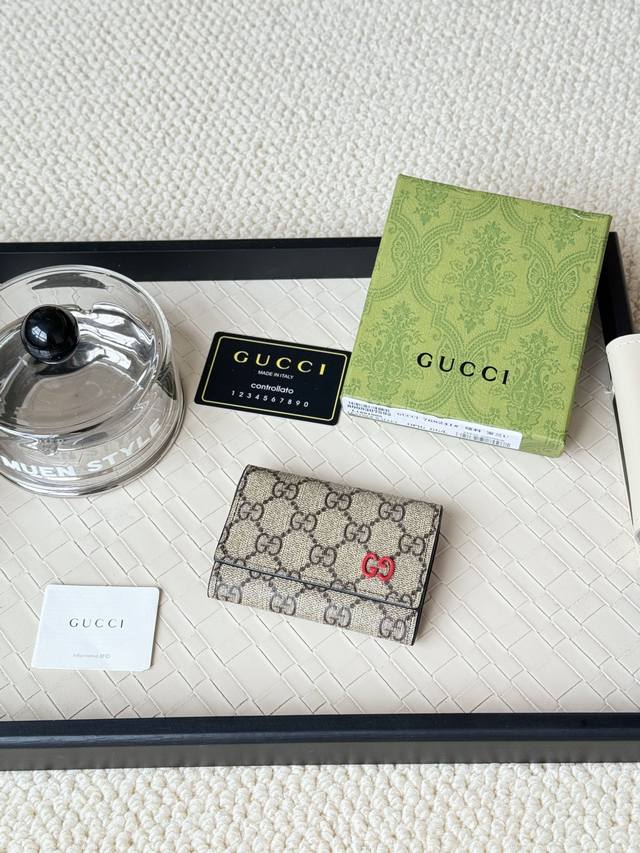Gucci multi-functional card holder with a brightly colored lining. The coin purs